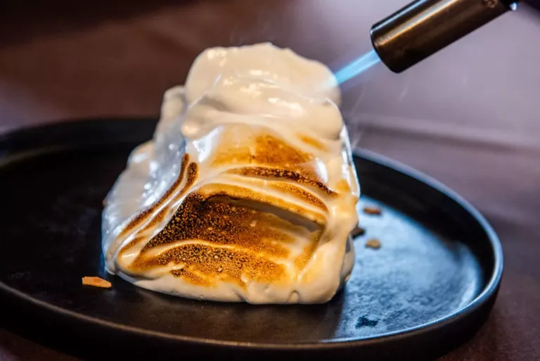 Postre de merengue caramelizando con un soplete