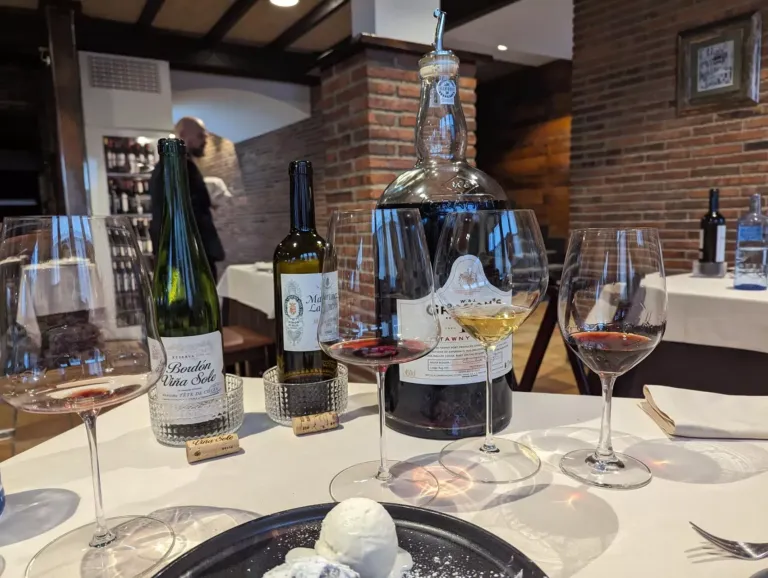 Mesa con vinos servidos y postre en primer plano en el asador de abel